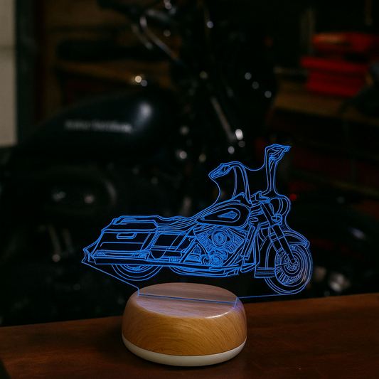 Motorcycle-shaped night light on a wooden surface with a blurred Fender background